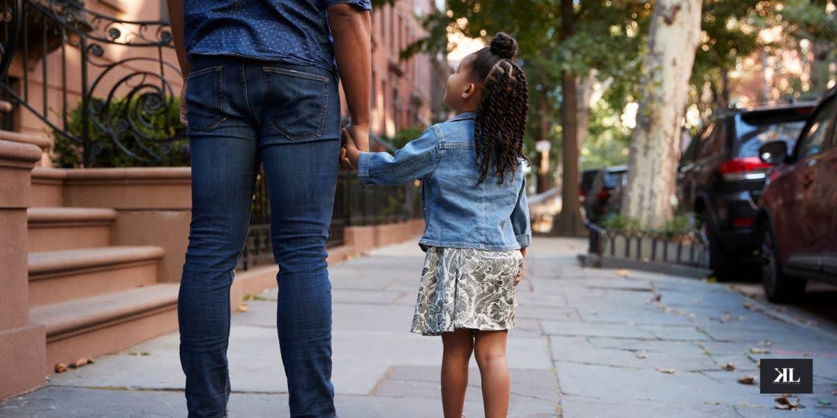 Adult and child holding hands on a New York City sidewalk, symbolizing parenting arrangements during legal separation in New York.